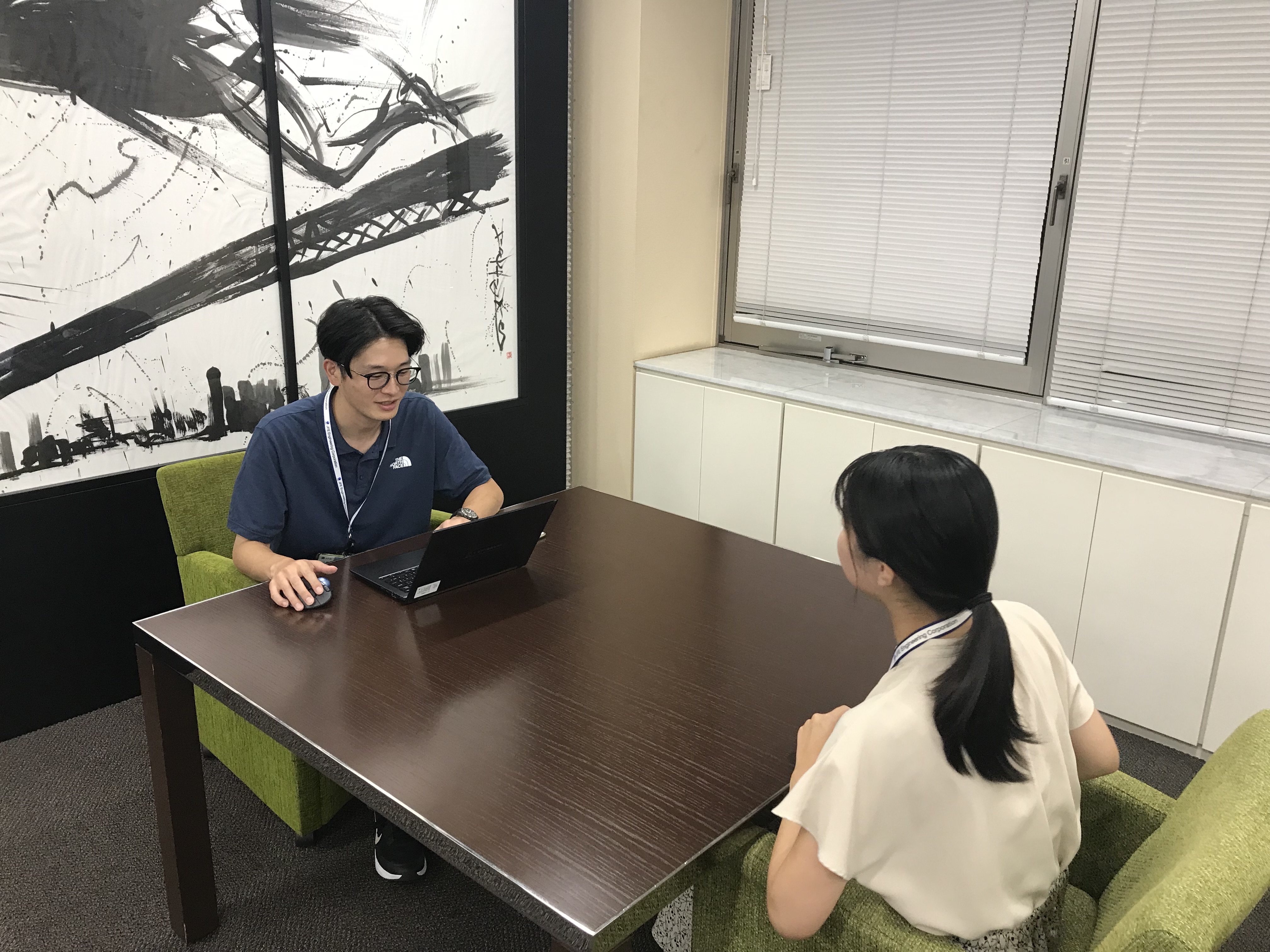 向かいあって会話をする社員