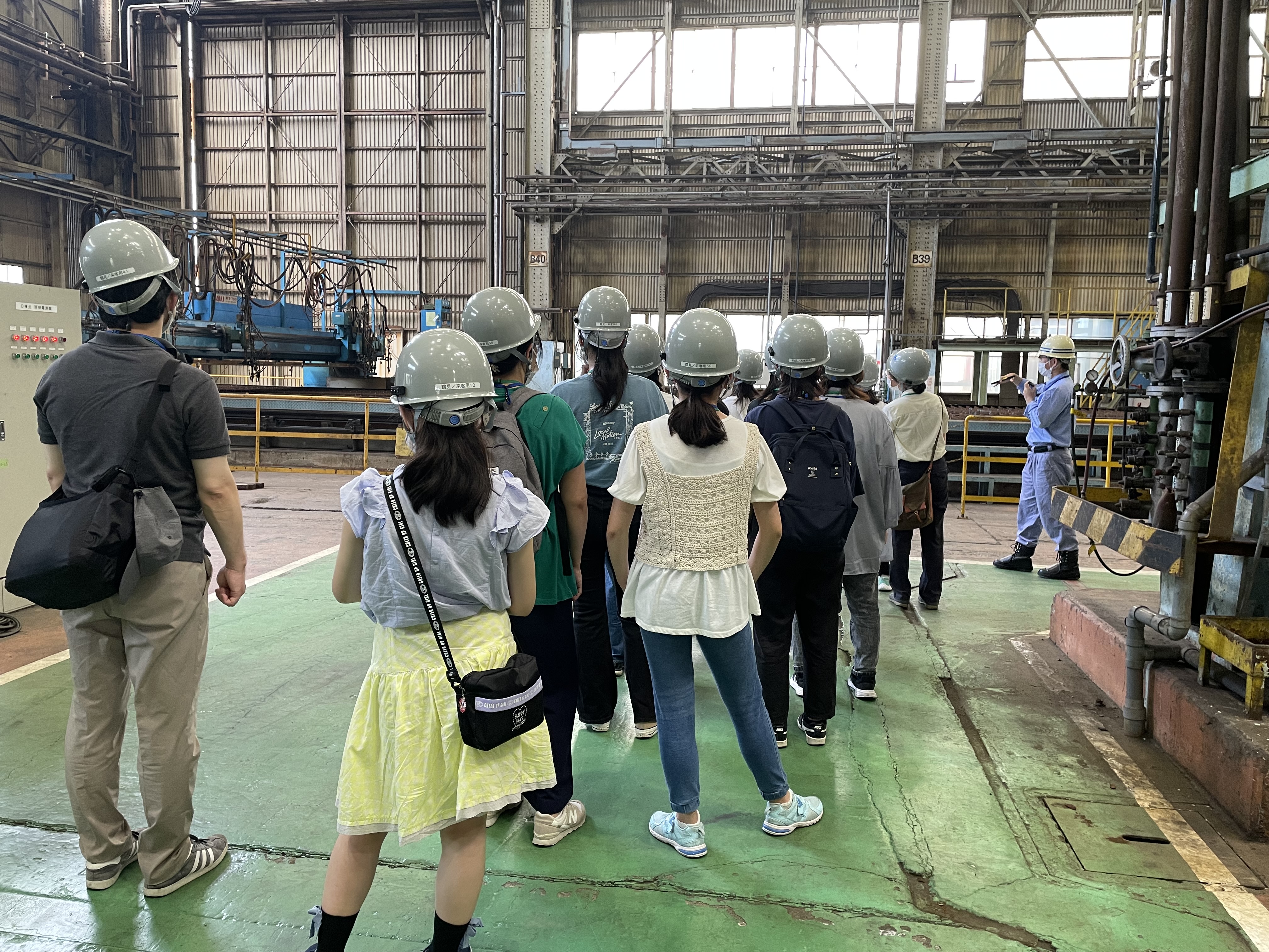 女子学生が工場見学をしている様子